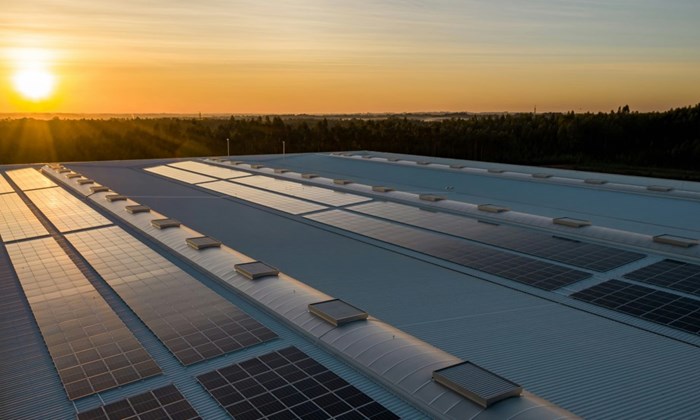 Solar panels on a roof with the sun setting