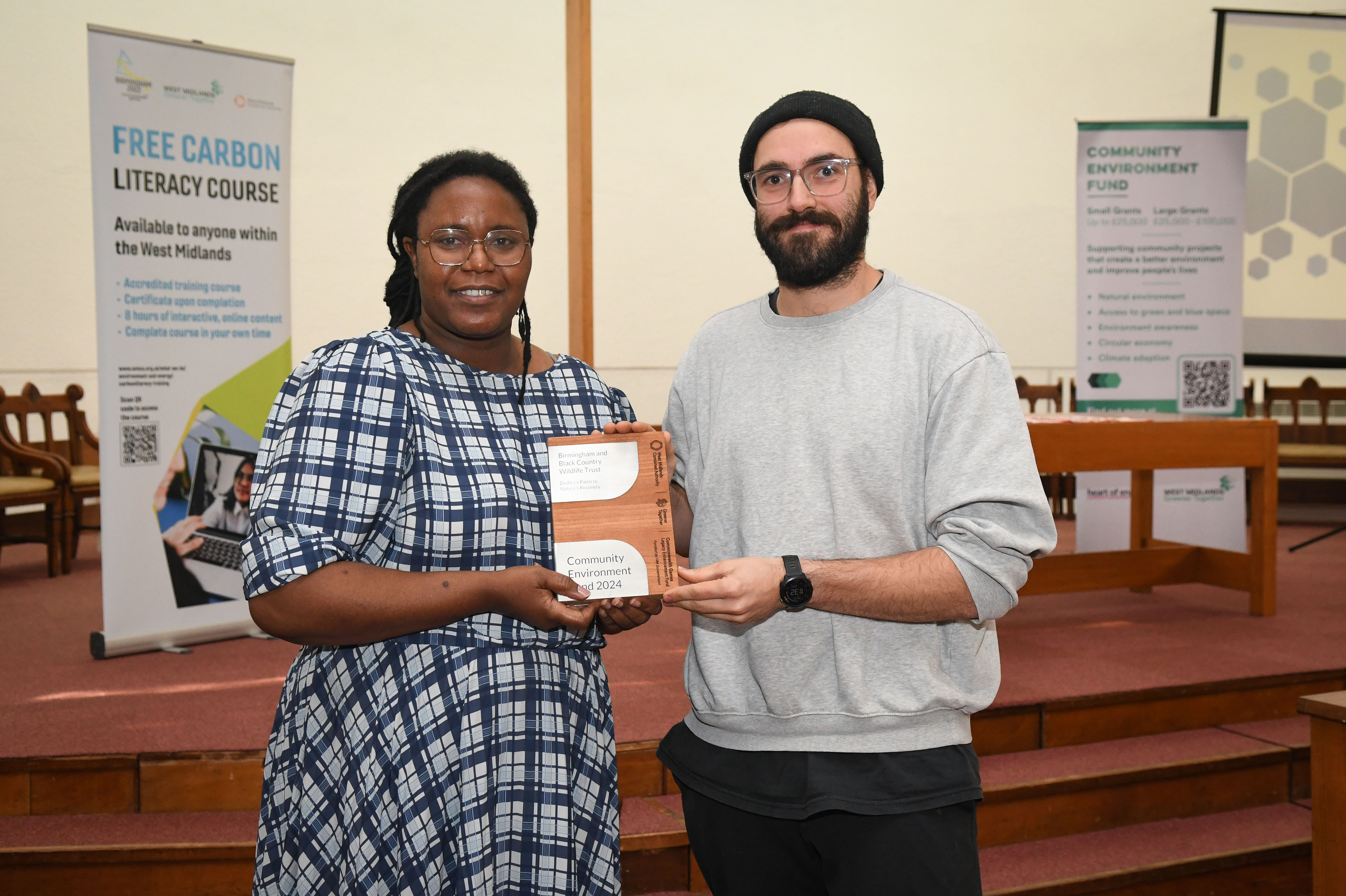 Two people at a wildlife conference. Holding a brochure.