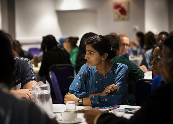 People seated at tables during a group event or workshop