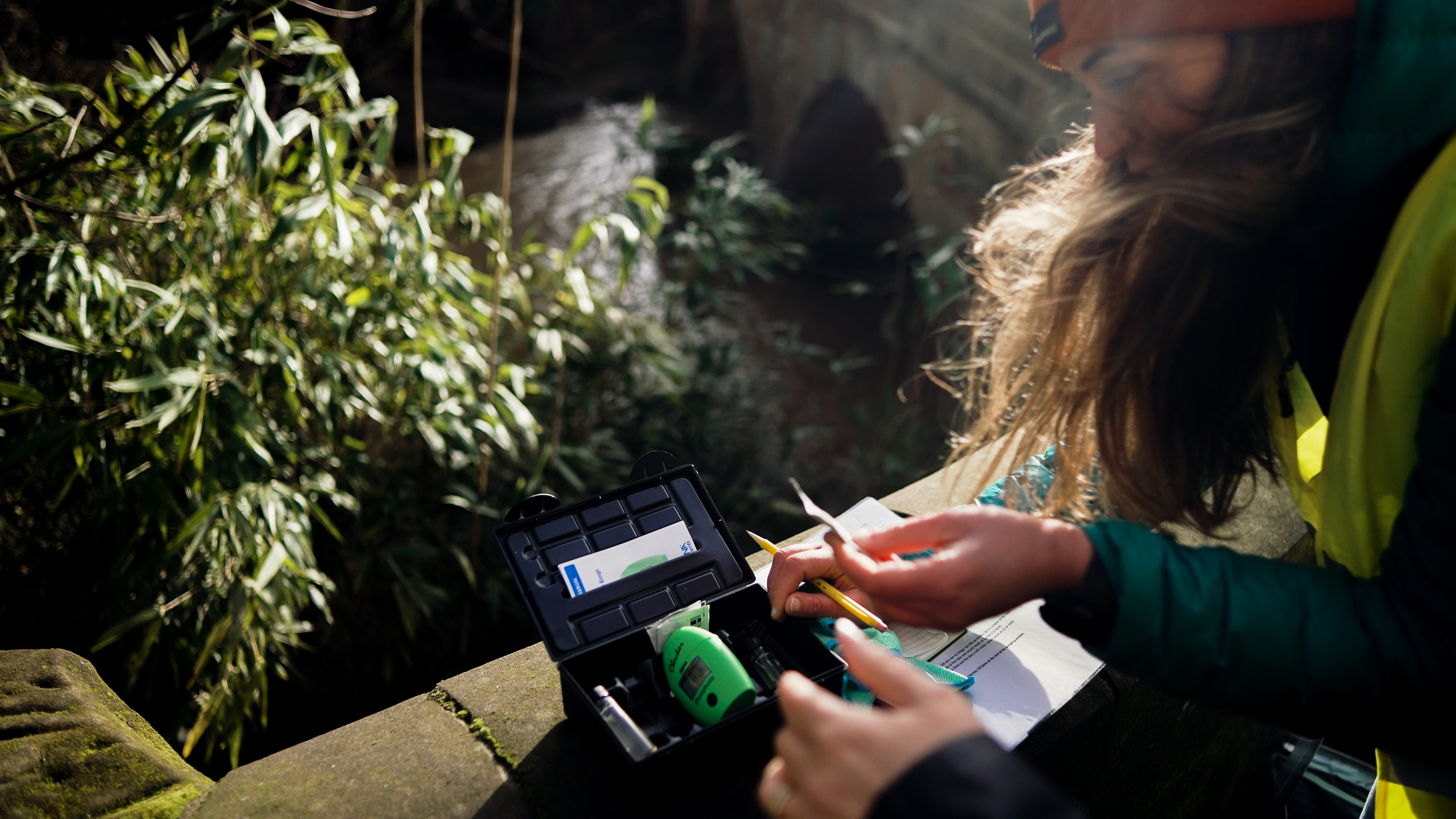 Someone surveying a river by a bridge