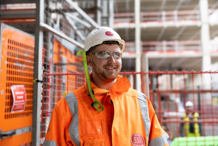 A man wearing hi vis jacket working on a building site.