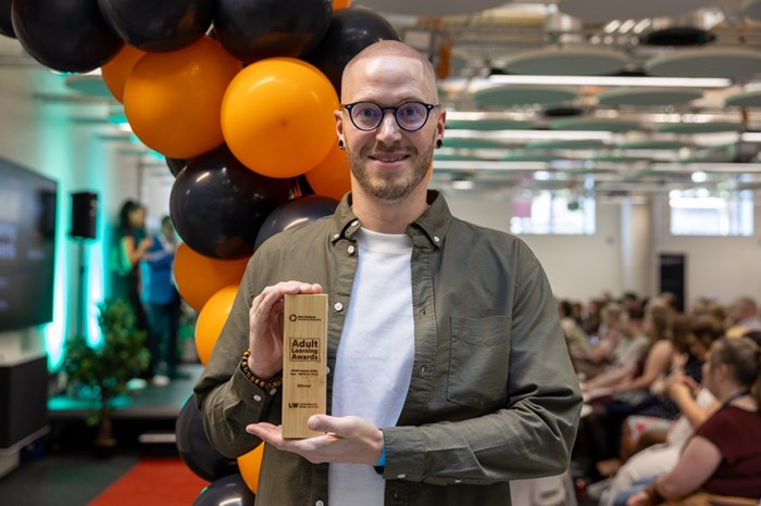 A man holding a trophy.