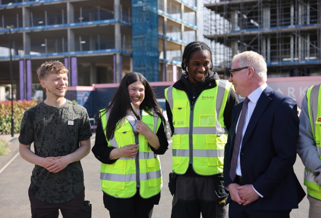 Photograph of Mayor Richard Parker stood talking to three young people (two men and one woman).