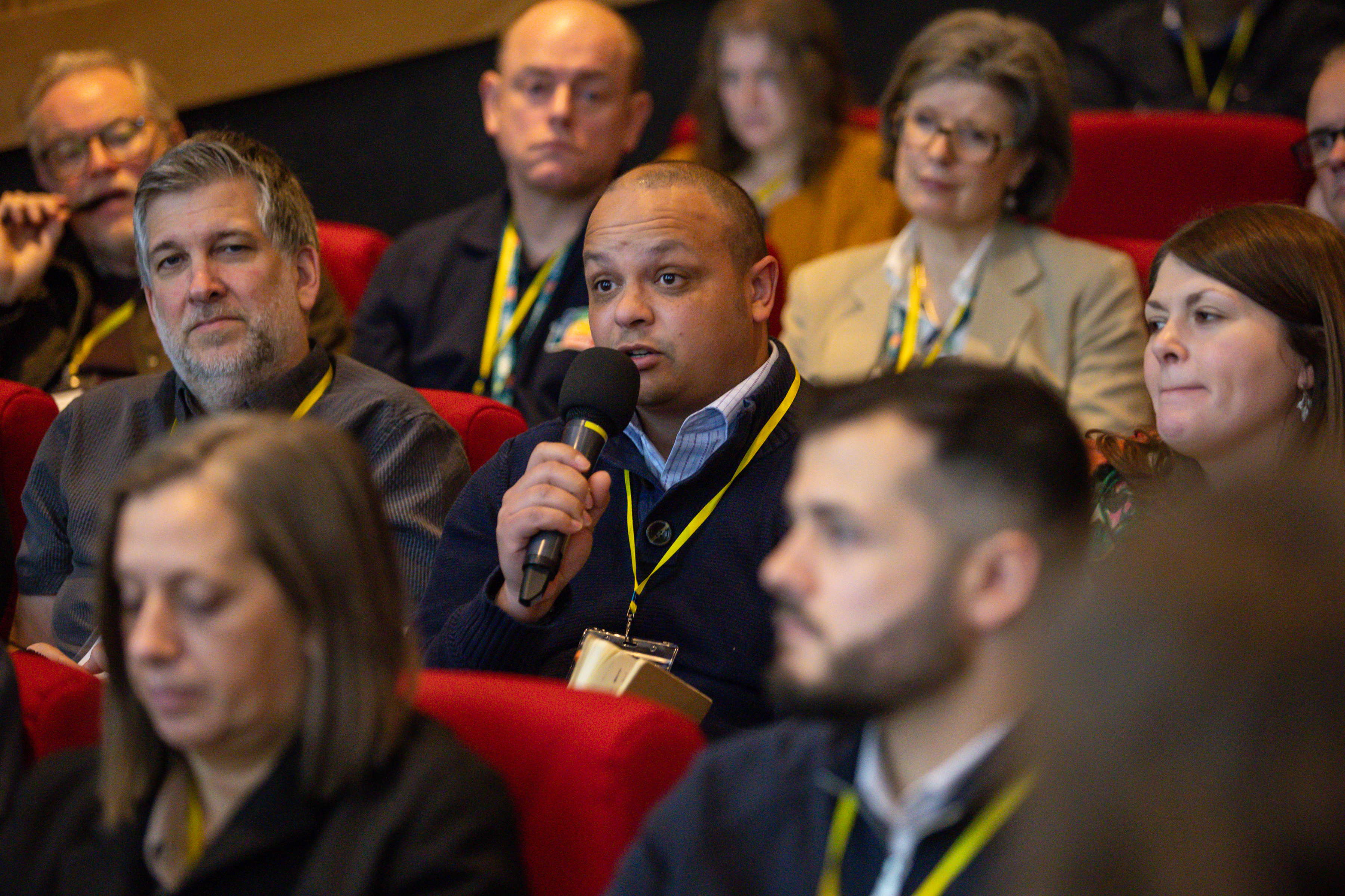 A guest at the conference in the audience with a microphone 
