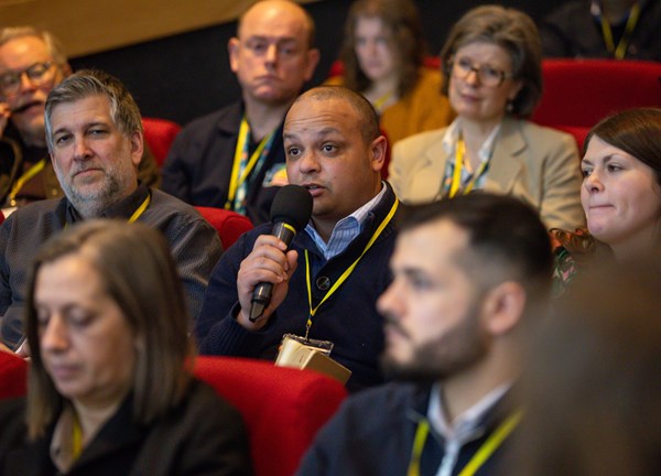 A guest at the conference in the audience with a microphone 