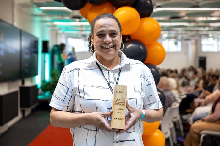 A woman holding a trophy.