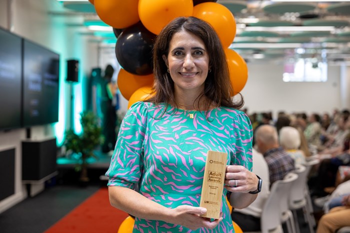 A woman holding a trophy.
