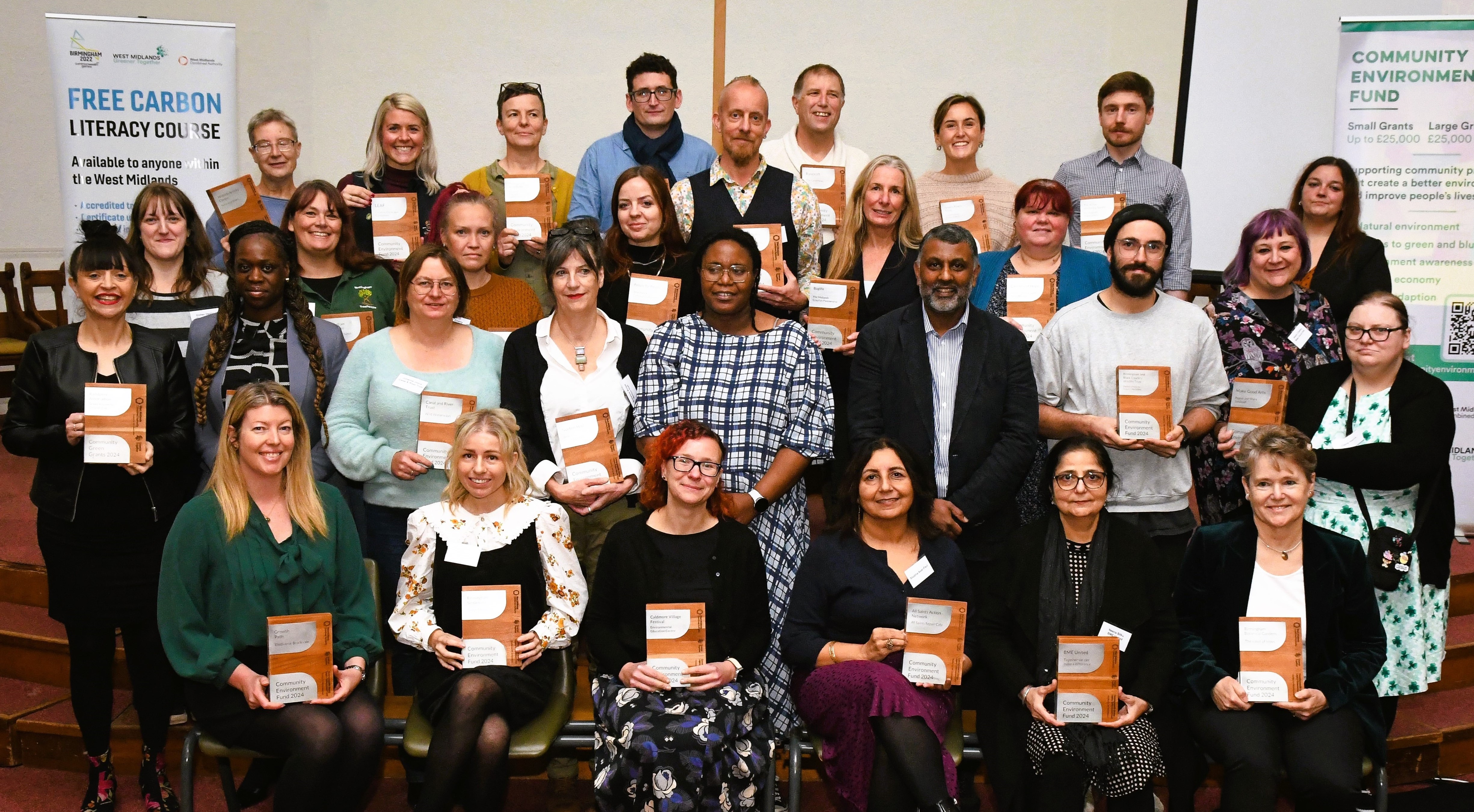 Group photo of the Community Environment Fund recipients holding their wooden awards.